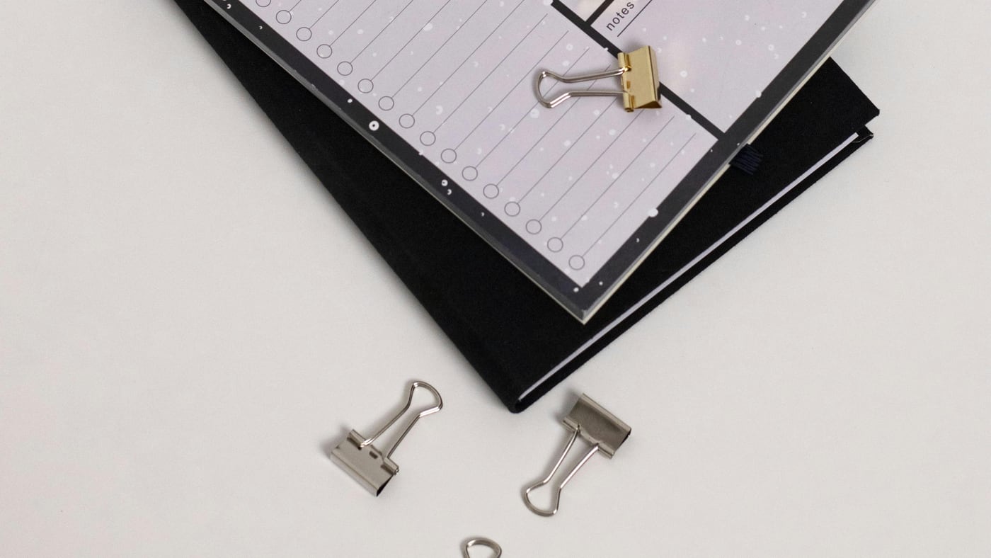 写着 Daily Notes 的计划本和桌面文具