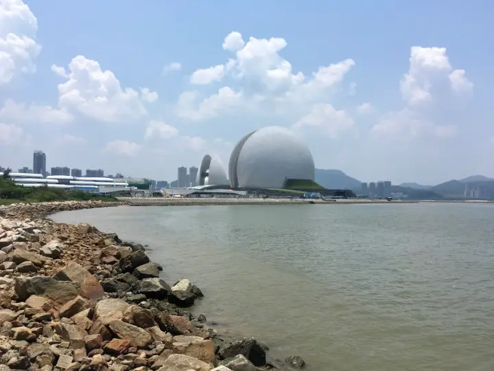 海边石岸望向远处的城市建筑