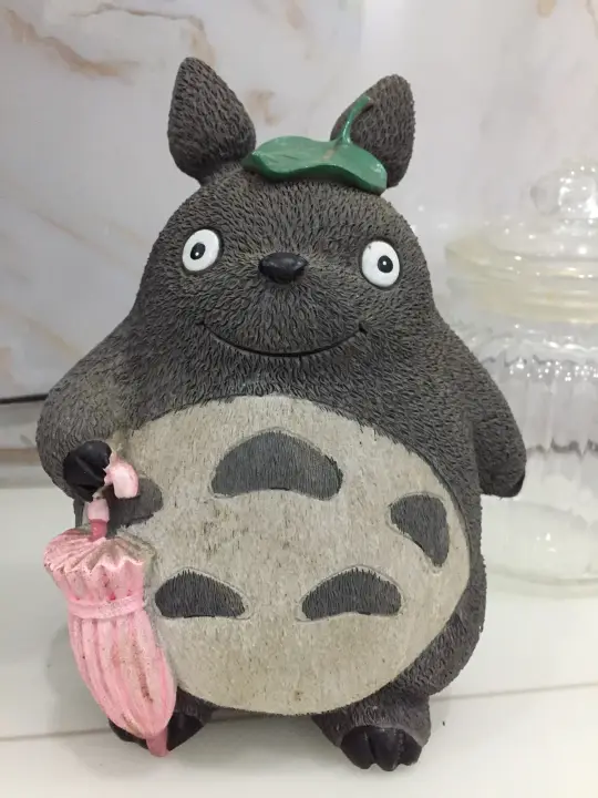 灰色玩偶与粉色小瓶的静物画面