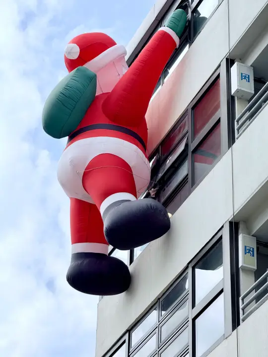 红色人形装置趴在建筑外墙上